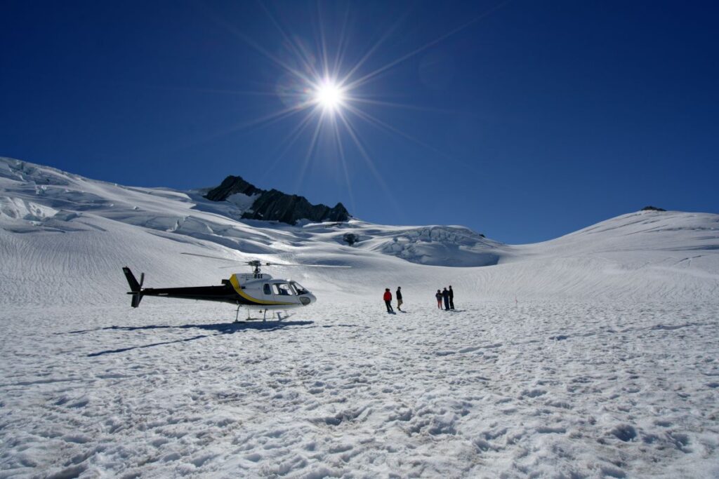 helikopter haalt expeditieleden op na bezichtiging keizerspinguins op Antarctica