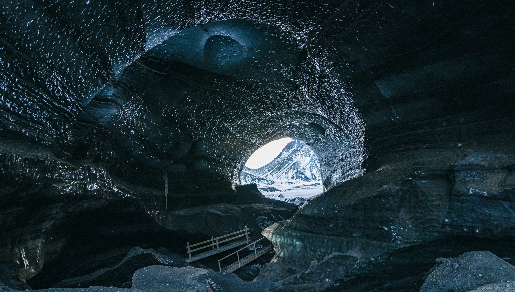 Gezicht vanuit een diepe ijsgrot op het bevroren landschap van Antarctica, symbool voor de verborgen wereld onder het ijs.