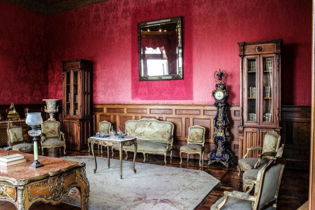kleurpsychologie door middel van een rood behang in een woonkamer met barok meubelen.