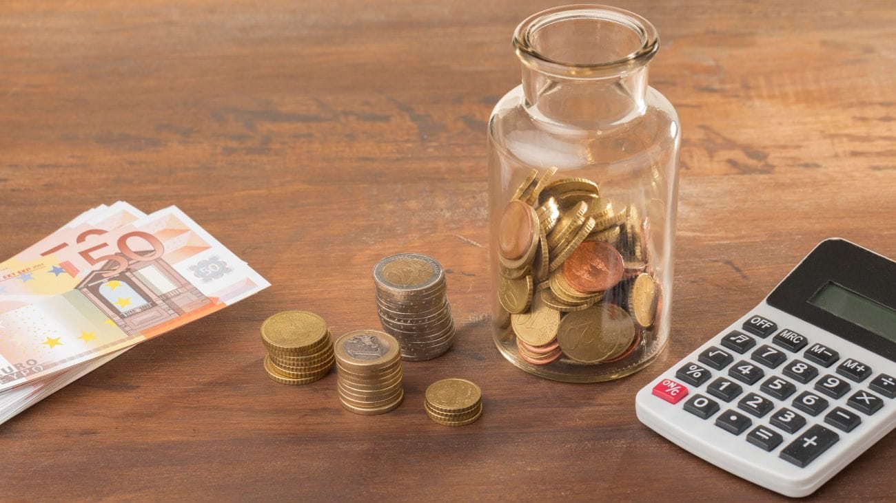 Rekenmachine en geld op tafel om de werkelijke autokosten voor de belastingdienst te berekenen.