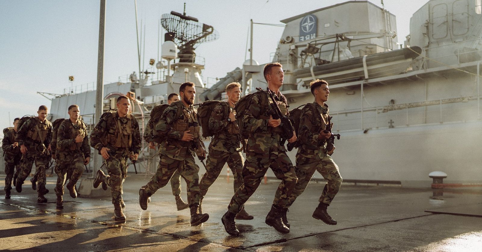 Nederlandse militairen in gevechtstenue bij een marineschip.