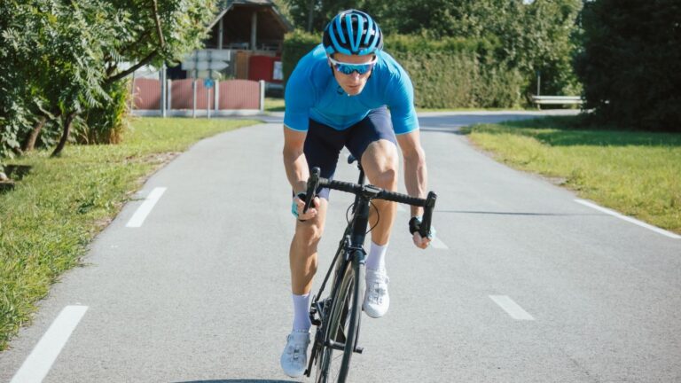 wielrenner uit het zadel tijdens sprinten op een landweg
