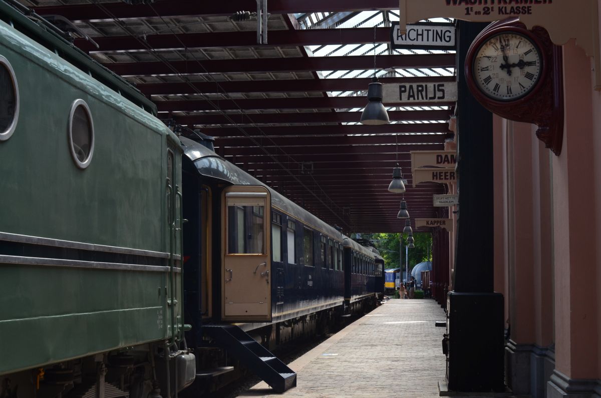 Historisch Nederlands perron met oude trein en stationsklok met Romeinse cijfers